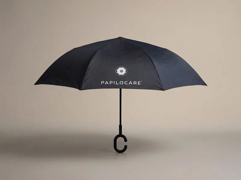 Paraguas negro plegable con logo Papilocare y mango en forma de C