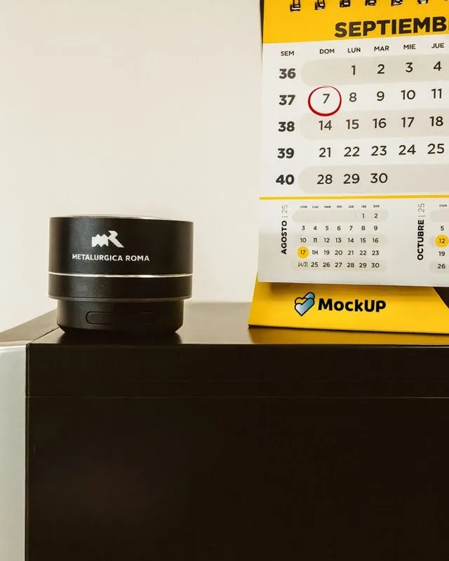 Calendario de escritorio MockUP junto a parlante negro Metalúrgica Roma