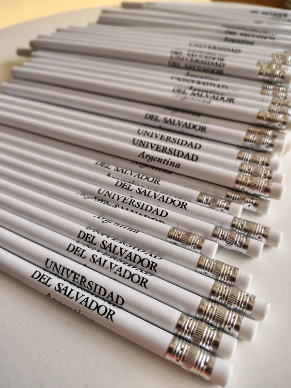 Pila de lápices grises grabados con el logo de la Universidad del Salvador