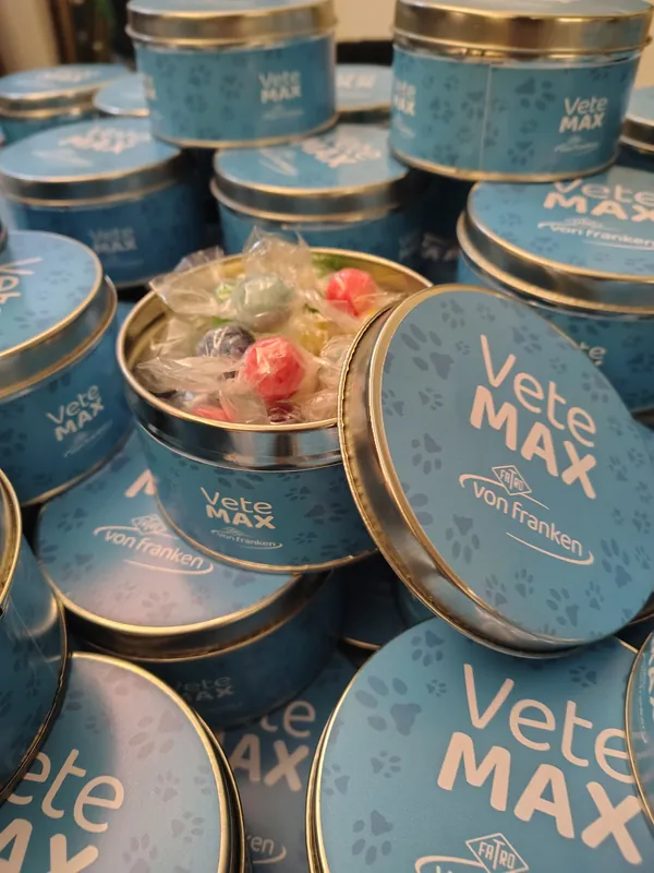 Latas metálicas azules con caramelos y el logo de VeteMax