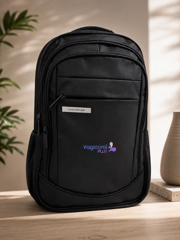 Mochila negra con el logo de Vagicural Plus apoyada sobre un banco de madera