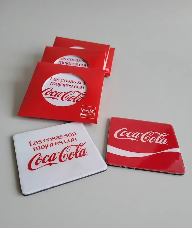Posavasos rojos y blancos con la frase Las cosas son mejores con Coca-Cola