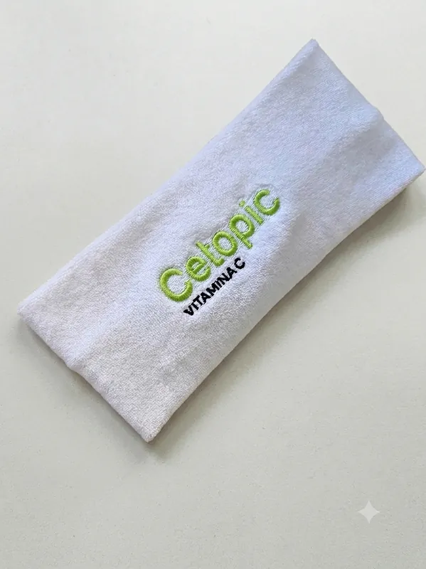 Vincha de toalla blanca bordada con el logo de Cetopic Vitamina C